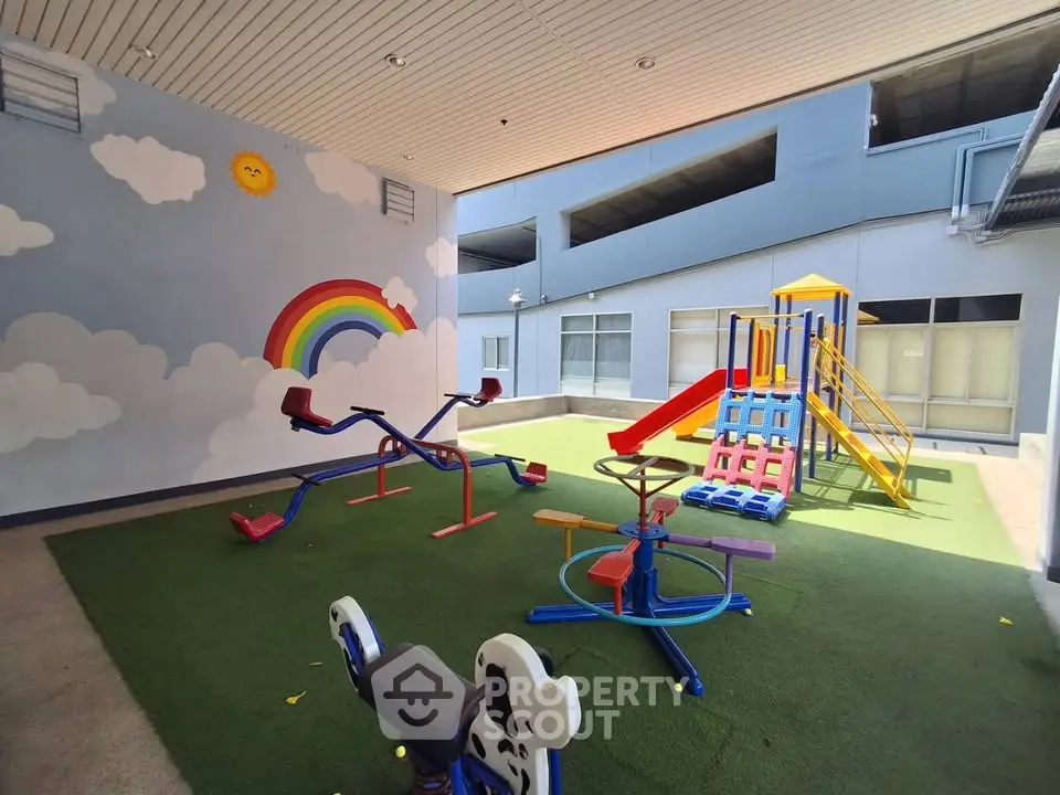 Charming indoor playground with colorful slides and seesaws in a modern residential complex.