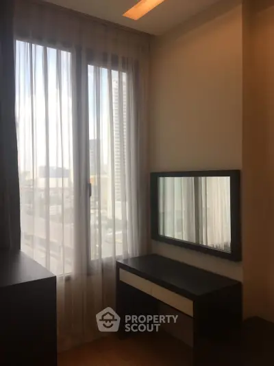 Modern bedroom with large window and stylish furniture in urban apartment