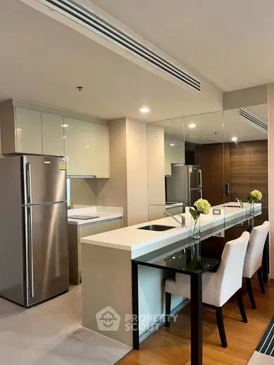 Modern kitchen with sleek design, featuring stainless steel appliances and elegant dining area.