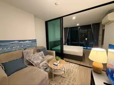 Modern living room with cozy sofa and adjacent bedroom separated by glass partition.