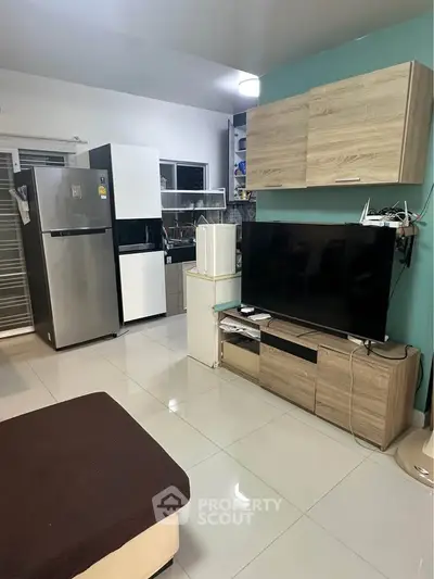 Modern living room with sleek TV unit and spacious kitchen area