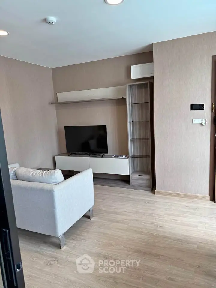 Modern living room with sleek furniture and mounted TV, perfect for cozy relaxation.