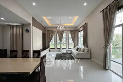 Spacious modern living room with elegant decor and large windows offering natural light.