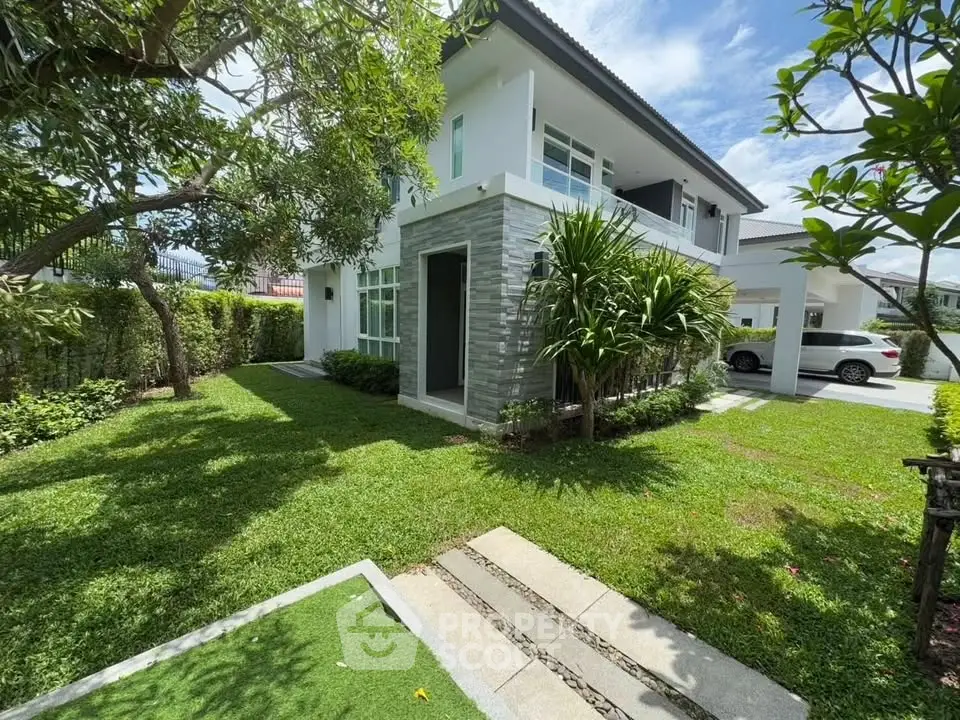 Charming two-story house with lush garden and driveway in serene neighborhood.