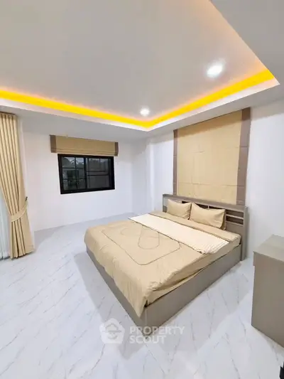 Spacious modern bedroom with elegant lighting and large window