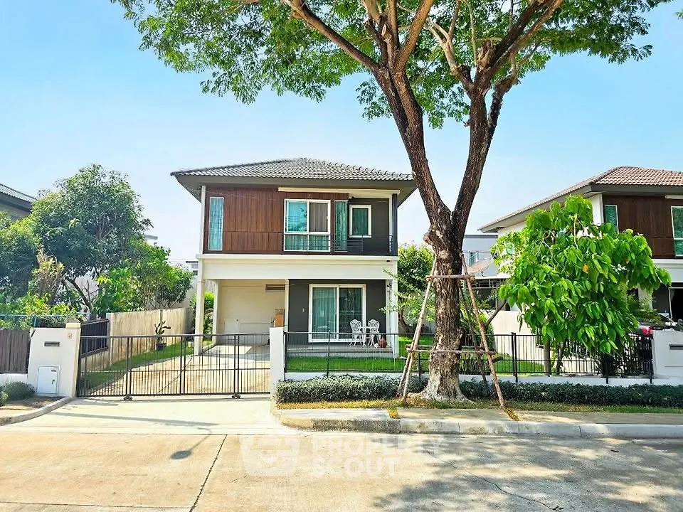 Charming two-story house with lush garden and spacious driveway in serene neighborhood.