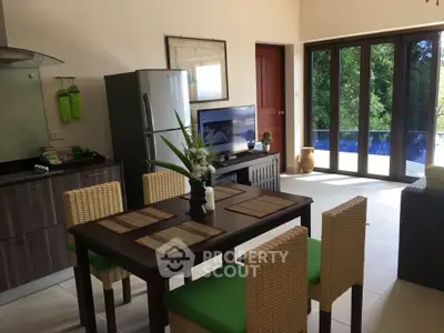 Charming open-plan kitchen and dining area with pool view, featuring modern appliances and stylish decor.