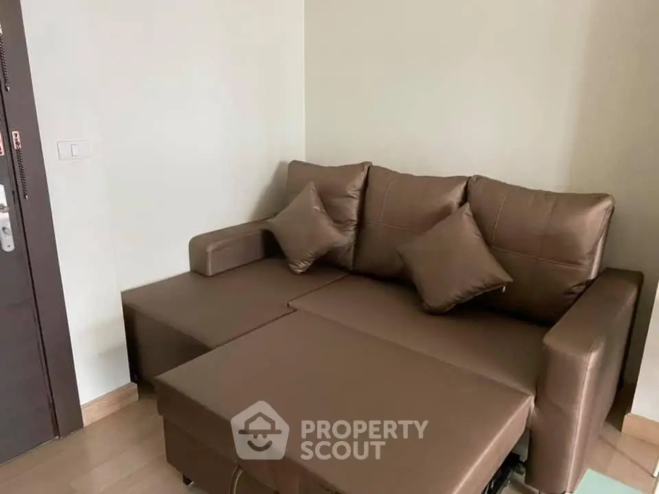 Cozy brown leather sofa bed in a modern living room corner, perfect for compact spaces.