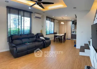 Spacious living room with modern decor and open layout to dining area.