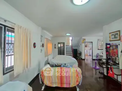 Spacious living room with vibrant decor and staircase in a cozy home.