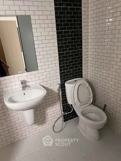 Modern bathroom with sleek white tiles and contemporary fixtures.