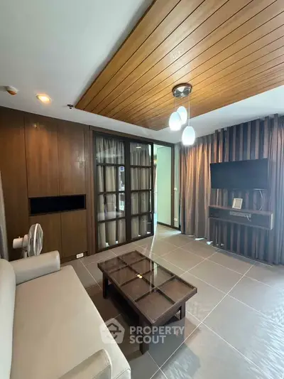Modern living room with wooden ceiling and stylish furniture in a cozy apartment.