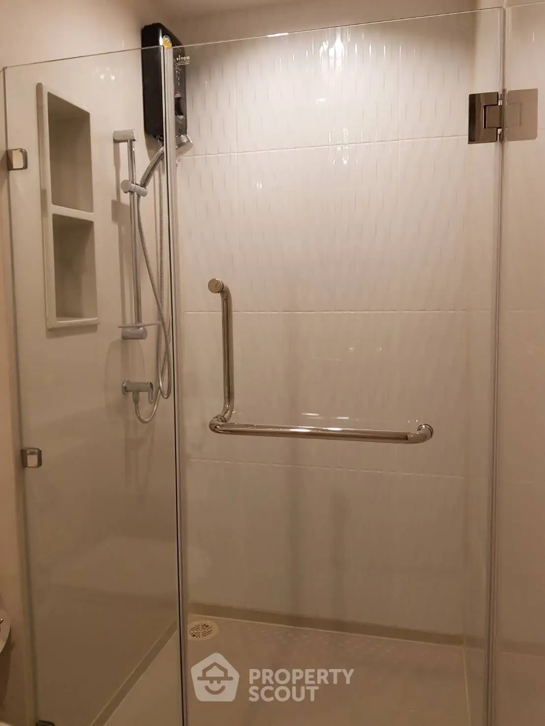 Modern bathroom with glass shower enclosure and safety grab bar