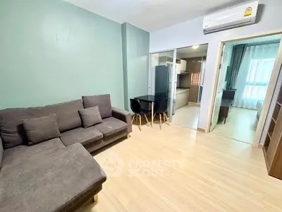 Modern living room with cozy sofa and open kitchen layout in stylish apartment.