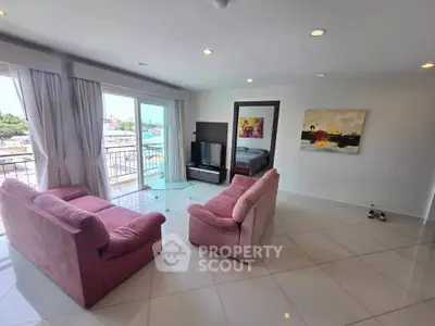 Spacious living room with pink sofas and balcony view in modern apartment