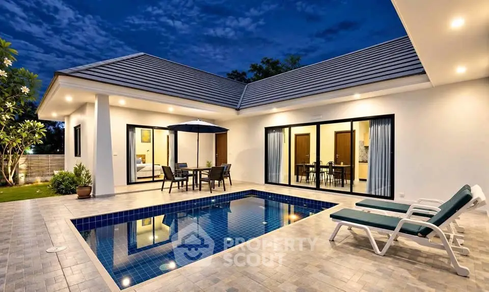 Luxurious modern villa with private pool and elegant outdoor seating area at dusk.