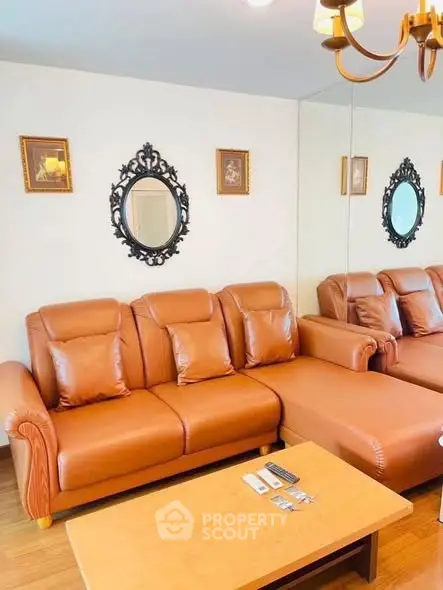 Elegant living room with leather sofa and decorative mirrors, perfect for cozy gatherings.
