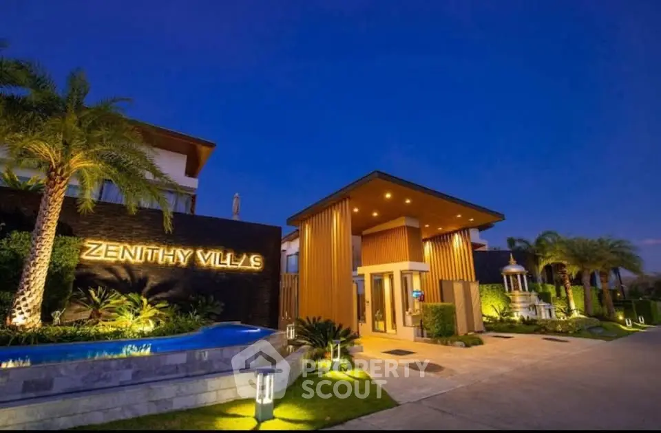 Luxurious entrance of Zenithy Villas with modern architecture and lush landscaping at dusk.