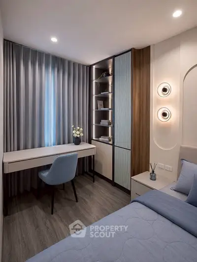 Modern bedroom with stylish decor and study area, featuring elegant lighting and sleek furniture.