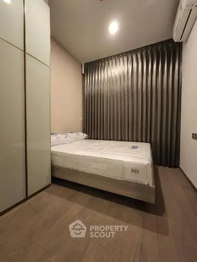 Modern bedroom with sleek design, featuring a comfortable bed and stylish curtains.