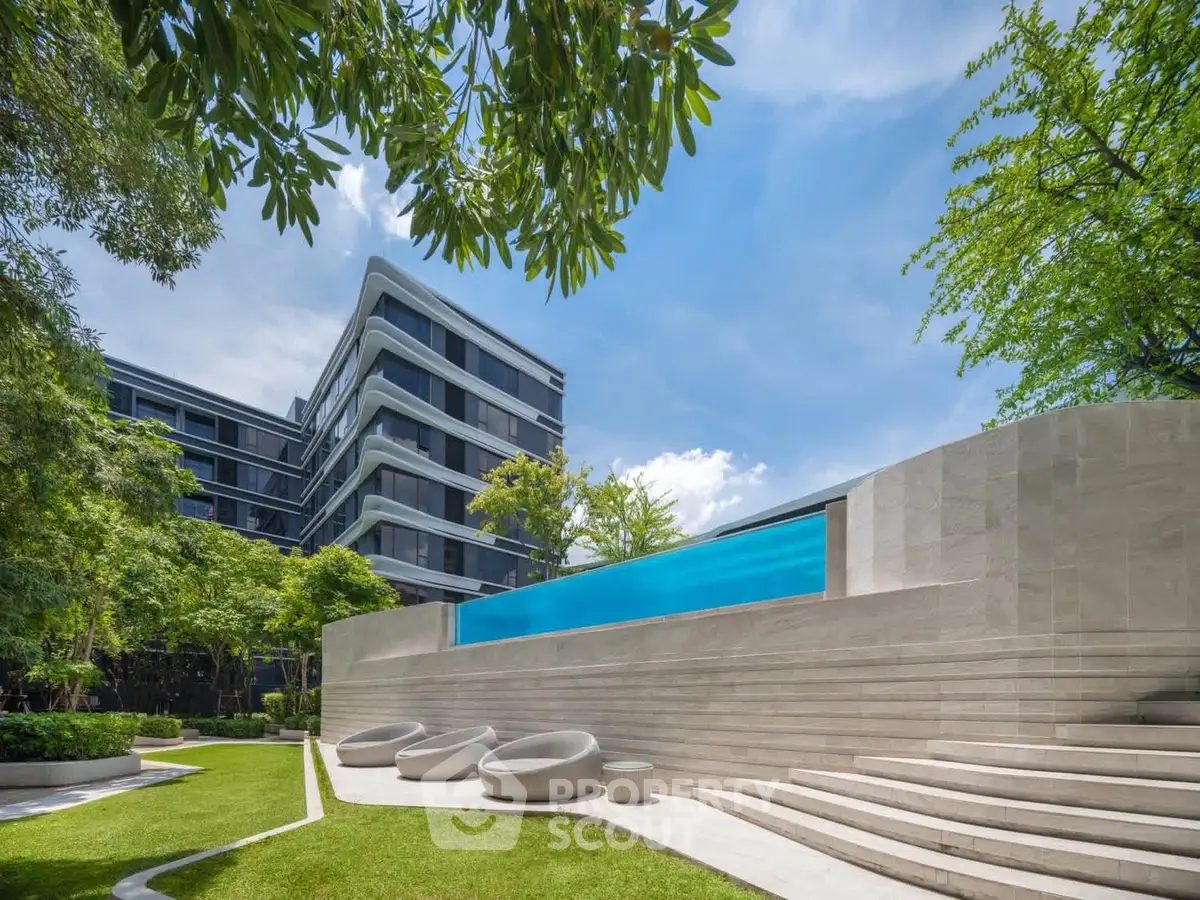 Luxurious modern building with stunning pool and lush green surroundings
