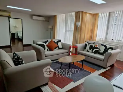 Spacious living room with modern furniture and large windows in a stylish apartment.
