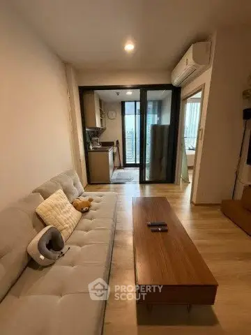 Modern living room with cozy sofa and open kitchen layout in a stylish apartment.
