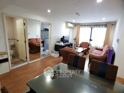 Spacious living room with modern furniture and dining area in a cozy apartment.