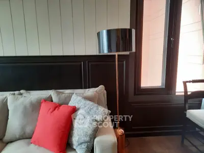 Stylish living room with modern lamp and cozy sofa featuring vibrant cushions.