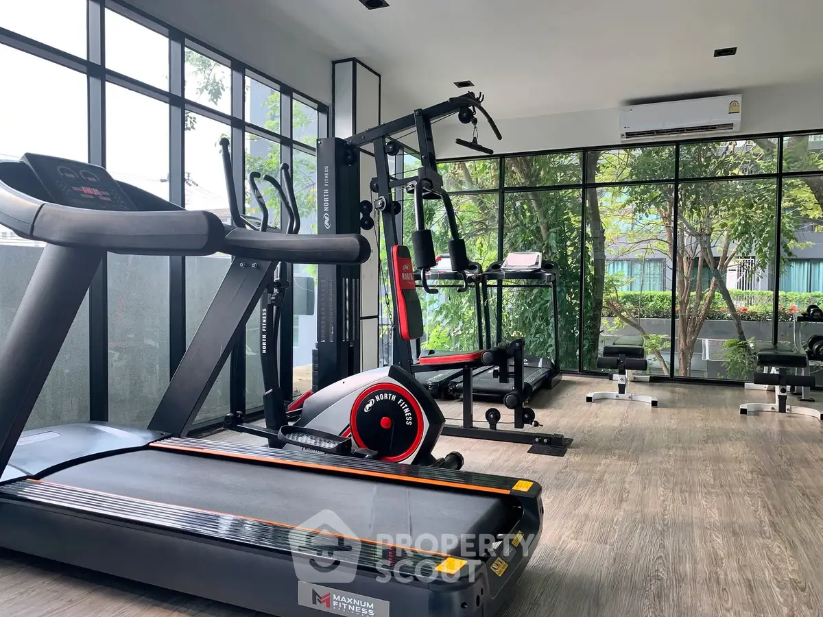 Modern gym with state-of-the-art equipment and large windows for natural light.