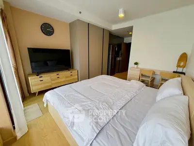 Modern bedroom with stylish furniture and large TV, perfect for comfortable living.