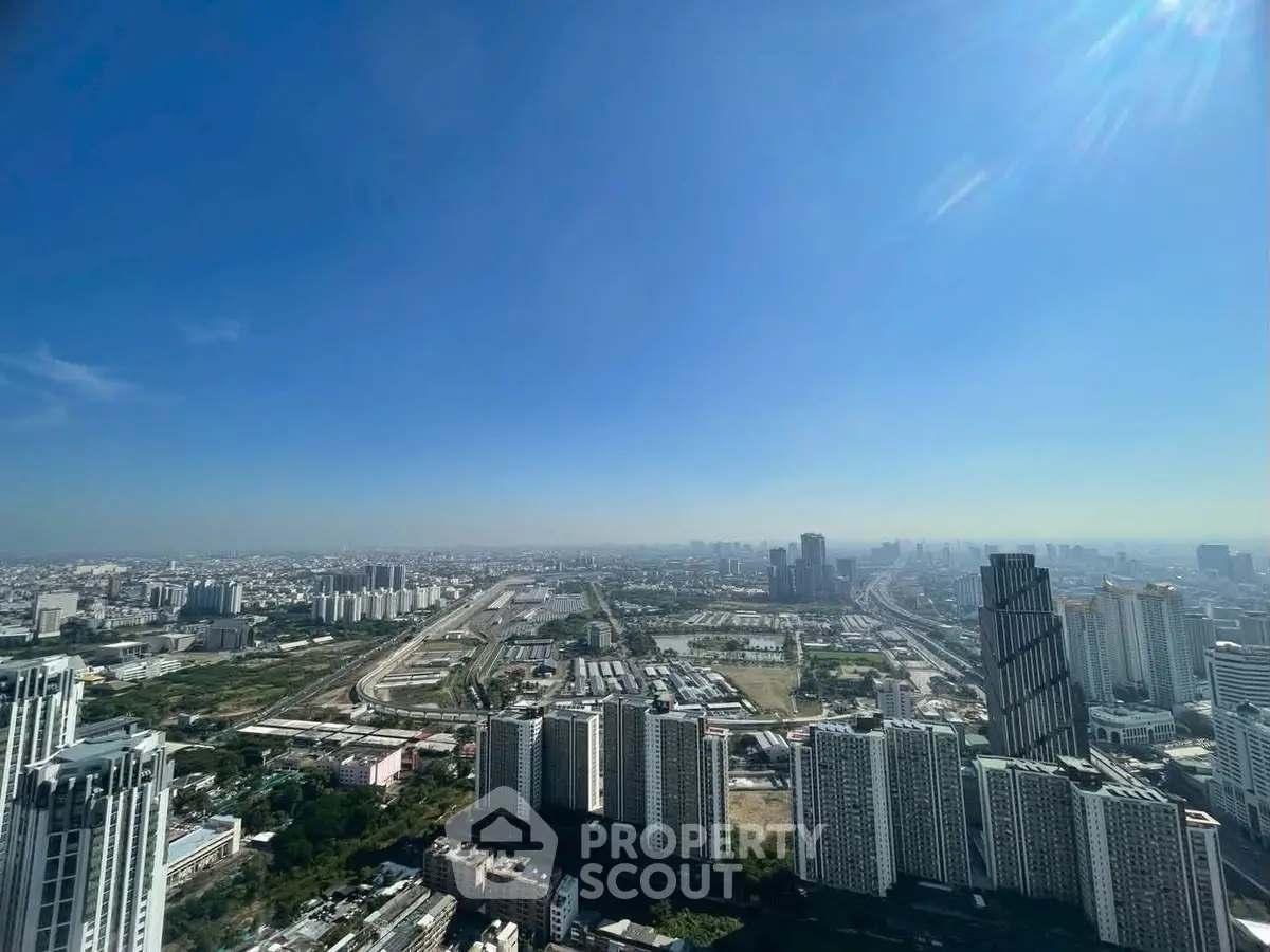 Stunning panoramic cityscape view from a high-rise building, showcasing urban skyline and clear blue sky.