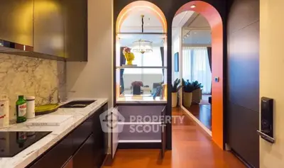 Stylish modern kitchen with marble countertops and open layout leading to a vibrant living area.