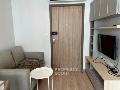 Cozy living room with modern furniture and entertainment setup in a compact apartment.
