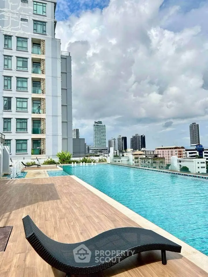 Luxurious rooftop pool with stunning city skyline views in modern high-rise building.