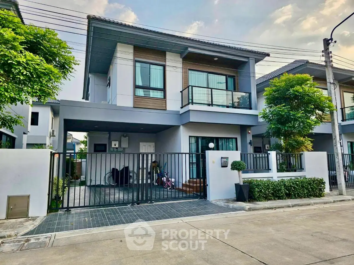 Modern two-story house with sleek design and spacious driveway in a serene neighborhood.