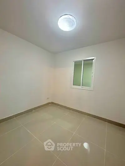 Minimalist empty room with tiled floor and window, ideal for customization.