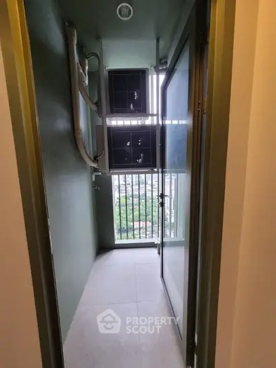 Compact balcony with utility area and city view, ideal for urban living.