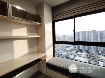 Modern study room with large window offering city view, built-in desk and shelves.