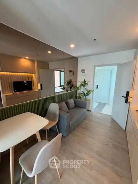 Modern living room with stylish furniture and open layout, featuring a cozy sofa and dining area.