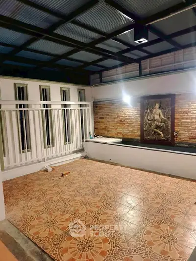 Charming covered patio with decorative tiles and brick accent wall, perfect for outdoor relaxation.