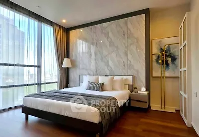 Luxurious bedroom with modern decor and large windows offering natural light and city views.