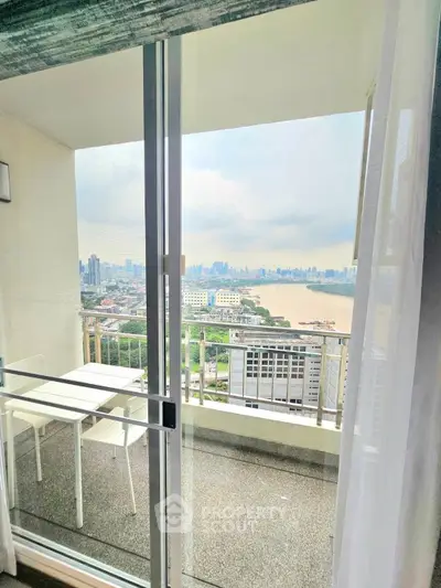 Stunning cityscape view from a high-rise balcony with modern seating.