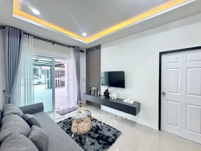 Modern living room with sleek decor and large window opening to outdoor view.