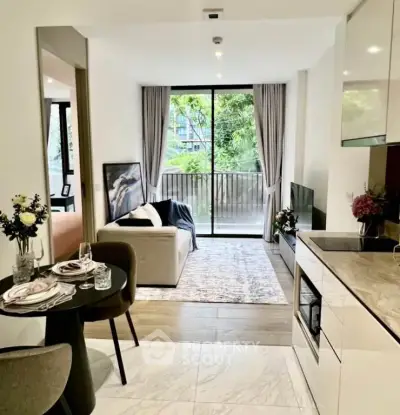 Modern open-plan living room with kitchen, featuring elegant decor and a view of the balcony.