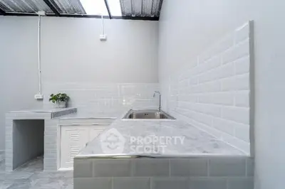 Modern minimalist kitchen with sleek marble countertops and white subway tile backsplash.