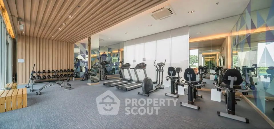 Modern gym with state-of-the-art equipment and mirrored walls in a luxury building.