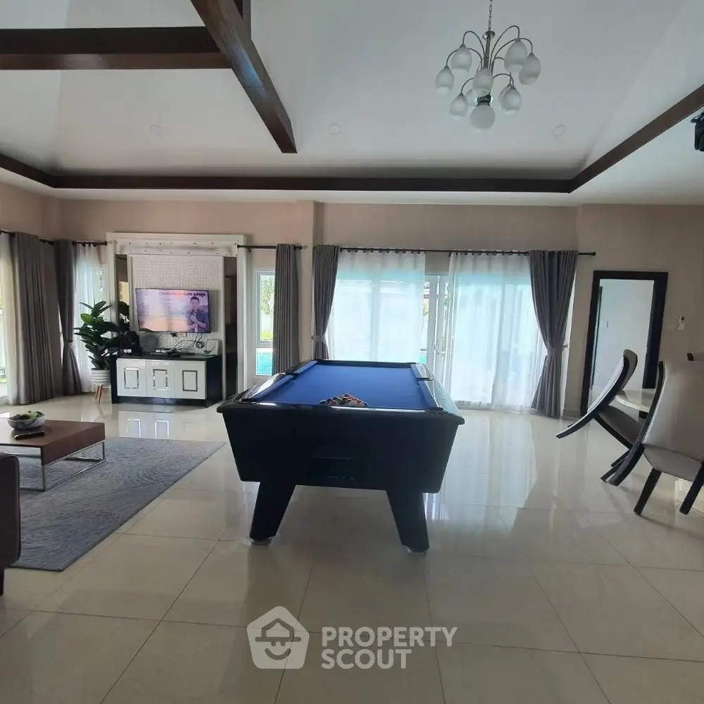 Spacious living room with pool table and modern decor, perfect for entertainment and relaxation.