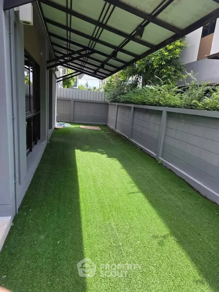 Charming outdoor garden space with lush artificial grass and modern fence, perfect for relaxation and leisure.