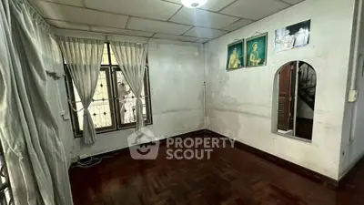 Spacious room with wooden flooring and large windows, ideal for customization and renovation.